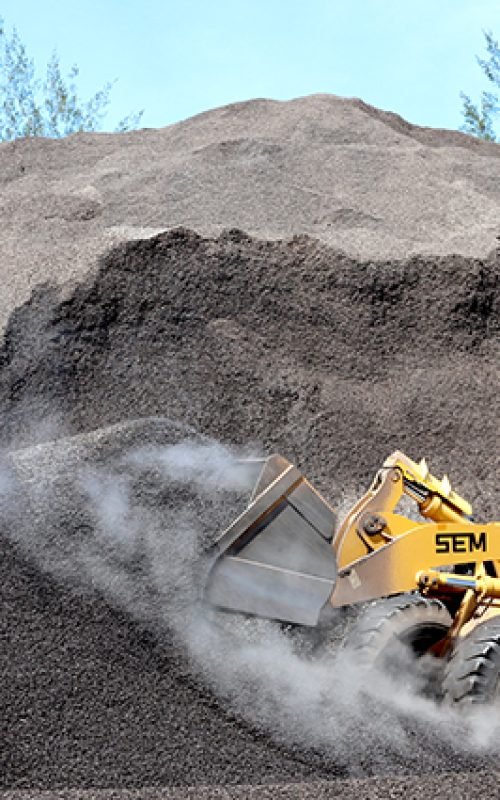 Bengkulu, Indonesia, January 18, 2023: Workers are collecting palm kernel shells using equipment and bulldozer vehicles that will be prepared for export as bio-energy feedstock